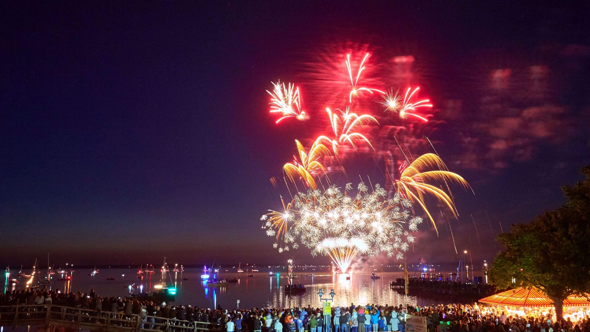Rote und gelbe Feuerwerksfontainen begeistern die Zuschauer des Feuerwerks vor der Promenade in Steinhude