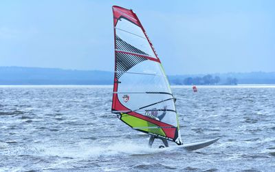 Windsurfer auf dem Steinhuder Meer Ein Windsurfer mit einem roten Segel gleitet über die Wasseroberfläche