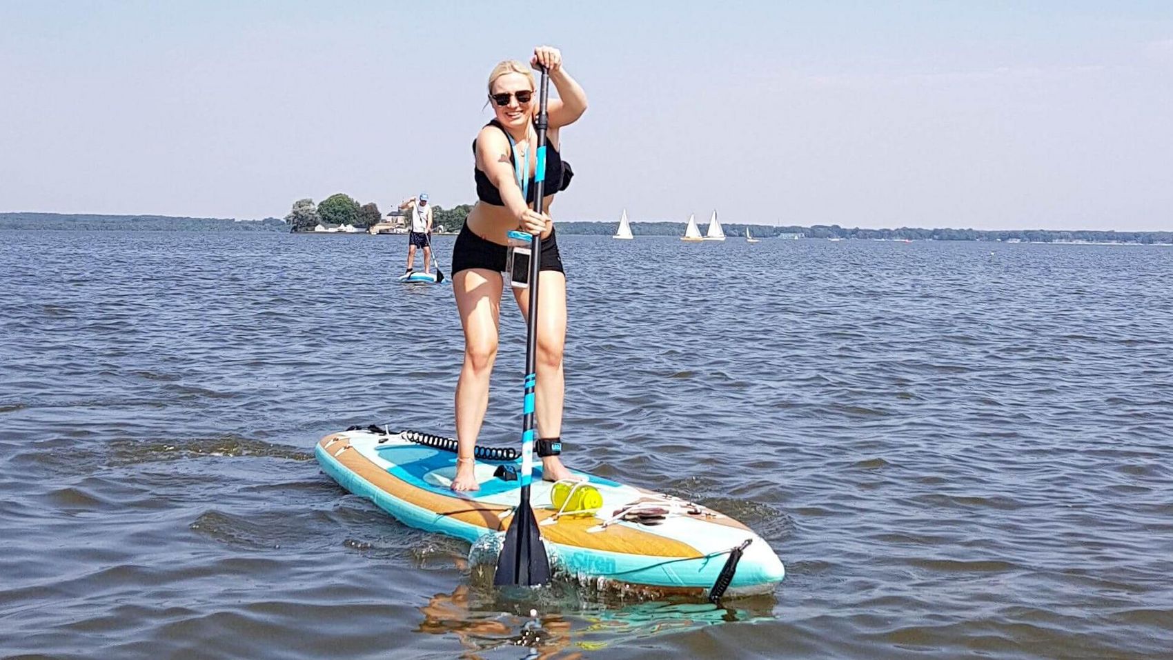 SUP - da stehen Sie drauf Eine junge Dame macht Stand Up Paddling auf dem Steinhuder Meer, im Hintergrund sieht man den Wilhelmstein