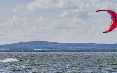 Kitesurfer auf dem Steinhuder Meer Ein Kitesurfer mit einem roten Schirm ist auf dem Meer unterwegs.