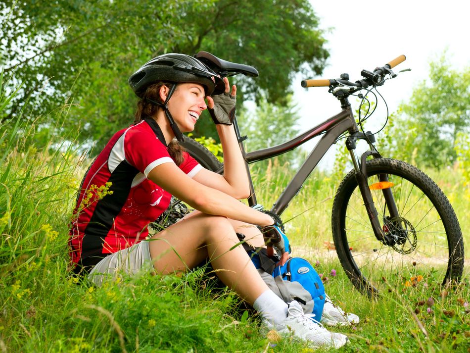 Radfahrerin macht Pause Eine Radfahrerin macht während ihrer Radtour ins Grüne eine Pause