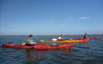 Kajaks in voller Fahrt auf dem Seinhuder Meer 3 Kajakfahrer paddeln in voller Fahrt in Formation durch die leichten Wellen des Steinhuder Meeres