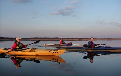 Kanufahrer auf Spiegelwasser Drei Kanufahrer spiegeln sich bei herrlichem Sonnenschein im Wasser