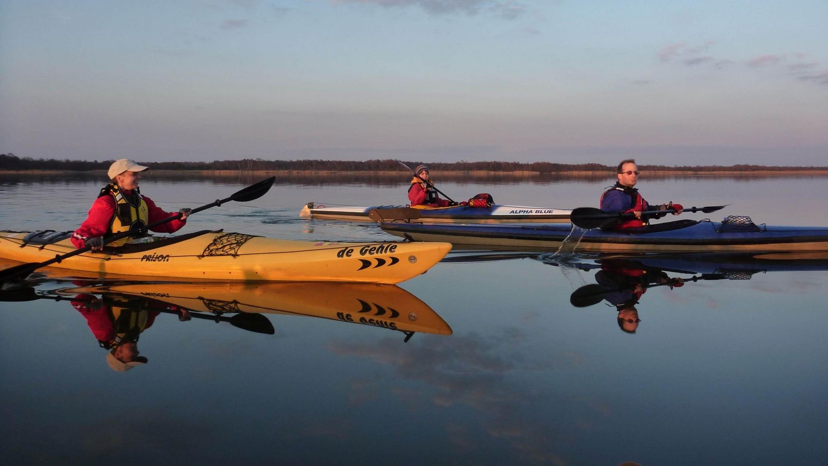 Kanufahrer auf Spiegelwasser Drei Kanufahrer spiegeln sich bei herrlichem Sonnenschein im Wasser