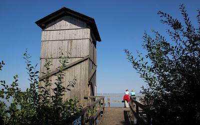 Aussichtsturm in Winzlar Zwei Personen stehen auf der Holzplattform neben dem Aussichtsturm am Steinhuder Meer bei Winzlar
