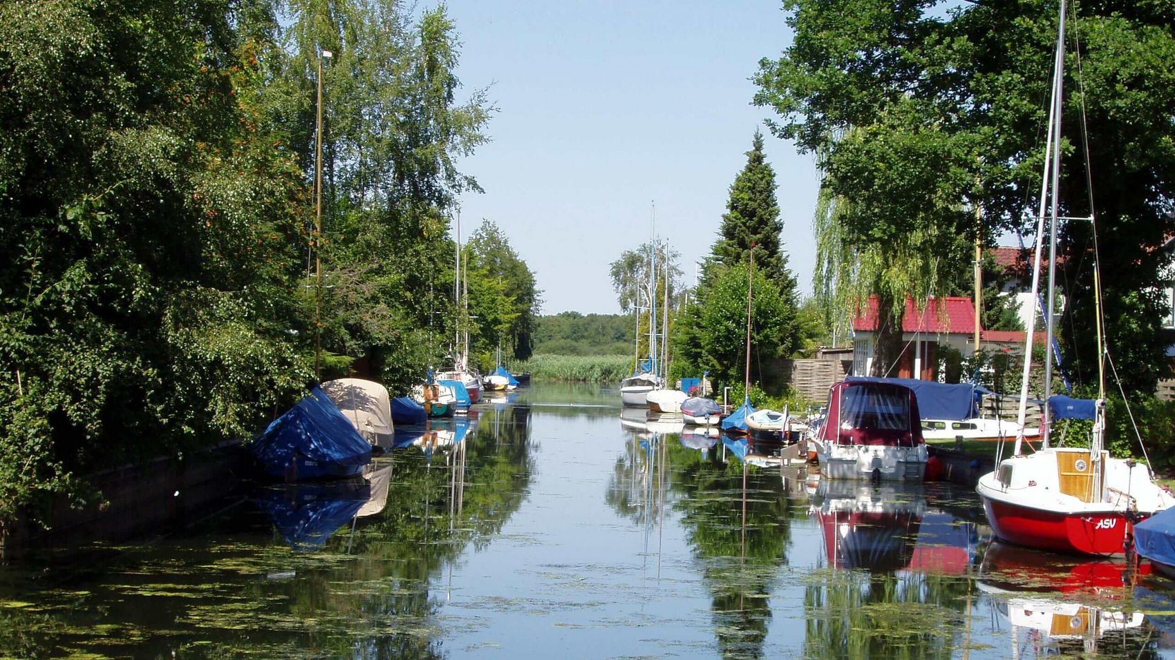Großenheidorn Grachten Die Grachten in Großenheidorn sind mit Grün bedeckt und Schiffe liegen auf dem Wasser