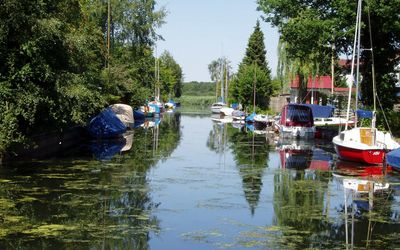 Großenheidorn Grachten Die Grachten in Großenheidorn sind mit Grün bedeckt und Schiffe liegen auf dem Wasser