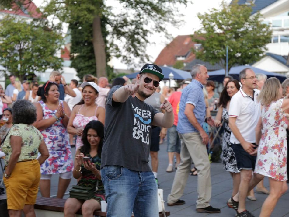 Im Publikum am Hafen vor der Seebühne posiert der Meerradio Moderator
