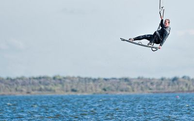 Kitesurfer im Sprung Zwei Wassersportler auf dem Steinhuder Meer nutzen den wolkenlosen Himmel