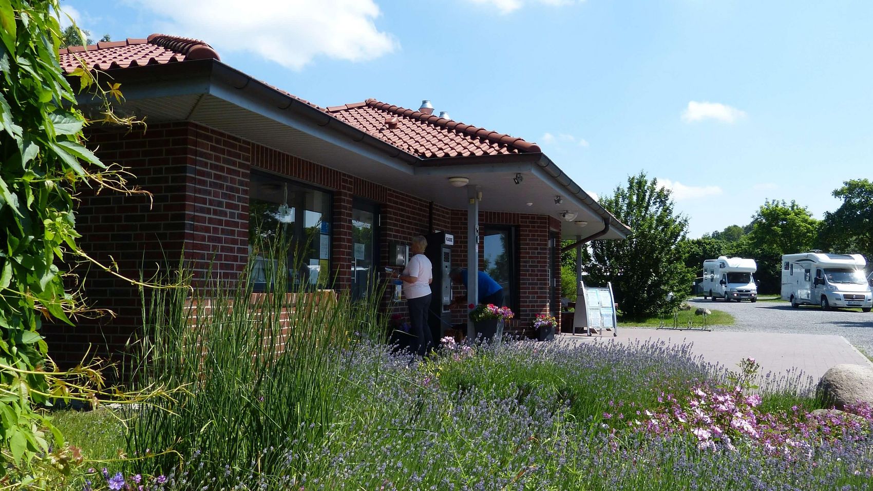 Wohnmobilstellplatz Steinhude Empfangsgebäude Das Empfangsgebäude des Wohnmobilstellplatzes Steinhude präsentiert sich an einem schönen Sommertag vor blauem Himmel und Wolken