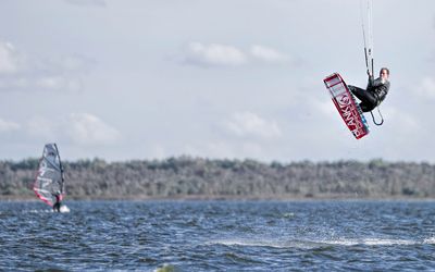 Kite- und Windsurfer Ein Kite-und ein Windsurfer surfen über das Meer