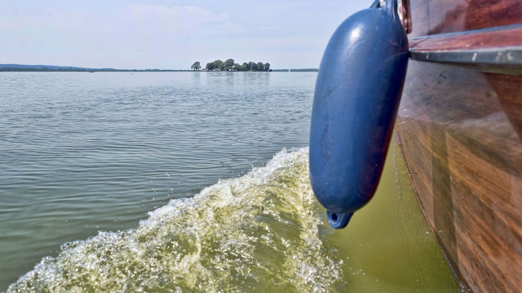 Auswanderer fährt Richtung Wilhelmstein Von der Aussenkante eines Auswanderer-Bootes sieht man die Insel Wilhelmstein