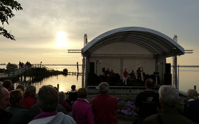 Seebühne Hafen Steinhude im Sonnenuntergang Die Seebühne liegt im Hafen von Steinhude. Die Sonne geht strahlend unter und das zahlreiche Publikum lauscht dem Konzert