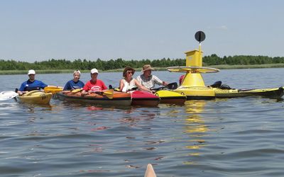 Kajaks an der Postboje Fünf Kajakfahrer haben sich an der schwimmenden gelben Bostboje im Ostenmeer versammelt
