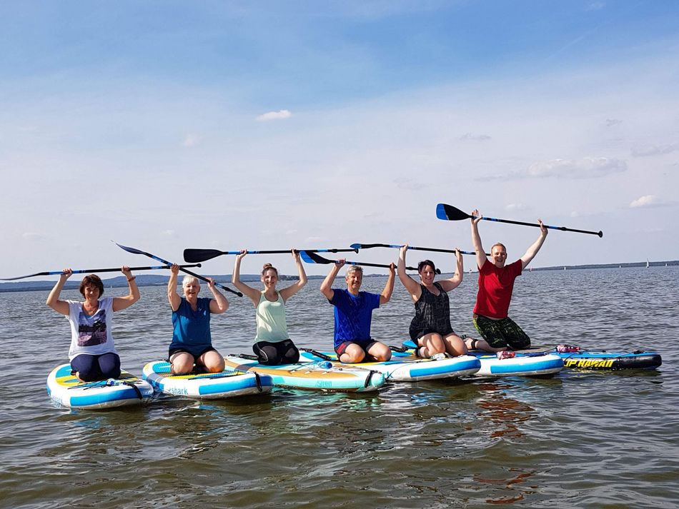 Stand up Paddling auf dem Steinhuder Meer Eine Gruppe sitzt während ihrer Stand up Paddling Tour auf den Boards. Im Hintergrund sieht man die Inselfestung Wilhelmstein
