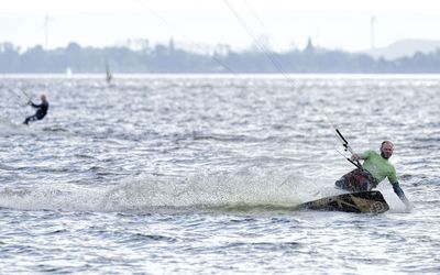 Kitesurfer auf dem Steinhuder Meer Ein Kitesurfer gleitet über das Steinhuder Meer. Im Hintergrund ist noch ein weiterer Surfer unterwegs.