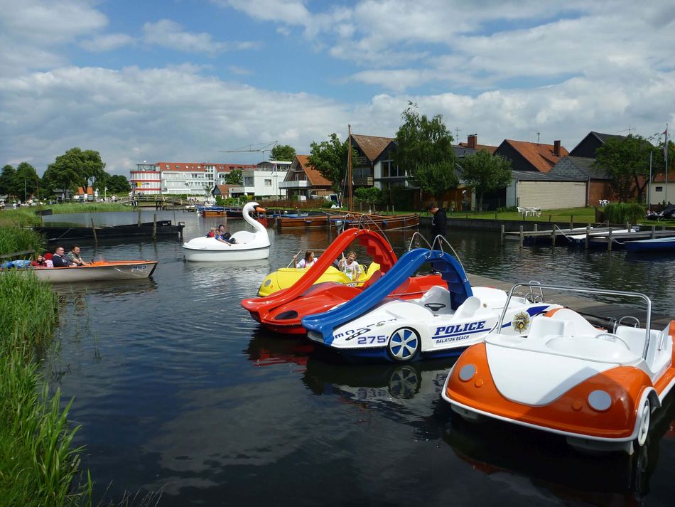 Bunte Tretboote an der Promenade in Steinhude Bunte Tretboote liegen am Steg im hellen Sonnenschein