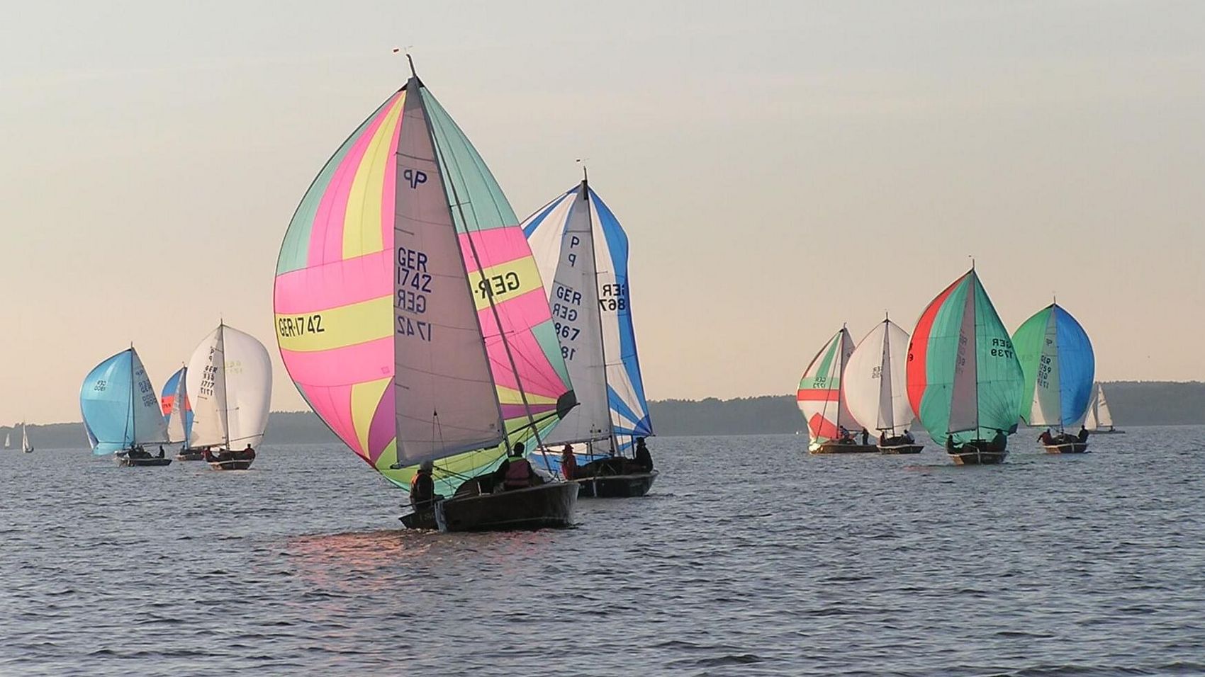 Regatta Neun Boote nehmen an einer Regatta auf dem Steinhuder Meer teil, alle haben das bunte Spinnakersegel gesetzt