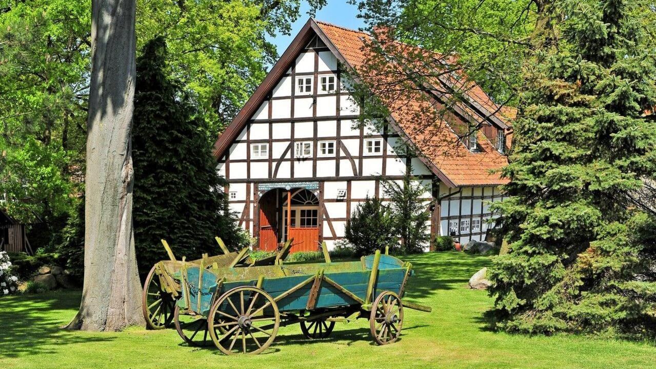 Fachwerkhaus Großenheidorn Ein weißes Fachwerkhaus in Großenheidorn steht hinter Büschen und Bäumen