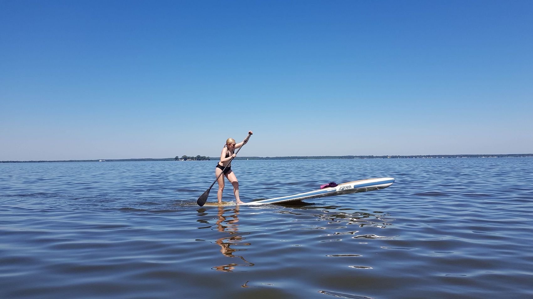 Stand up Paddling auf dem Steinhuder Meer Eine Frau paddelt mit ihrem Board über das Steinhuder Meer. Im Hintergrund sieht man die Inselfestung Wilhelmstein.