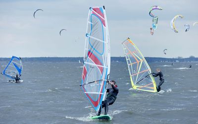 Windsurfer auf dem Steinhuder Meer Einige Windsurfer sind auf dem Steinhuder am Nordurfer unterwegs. Im Hintergrund sind auch Kitesurfer auf dem Wasser.